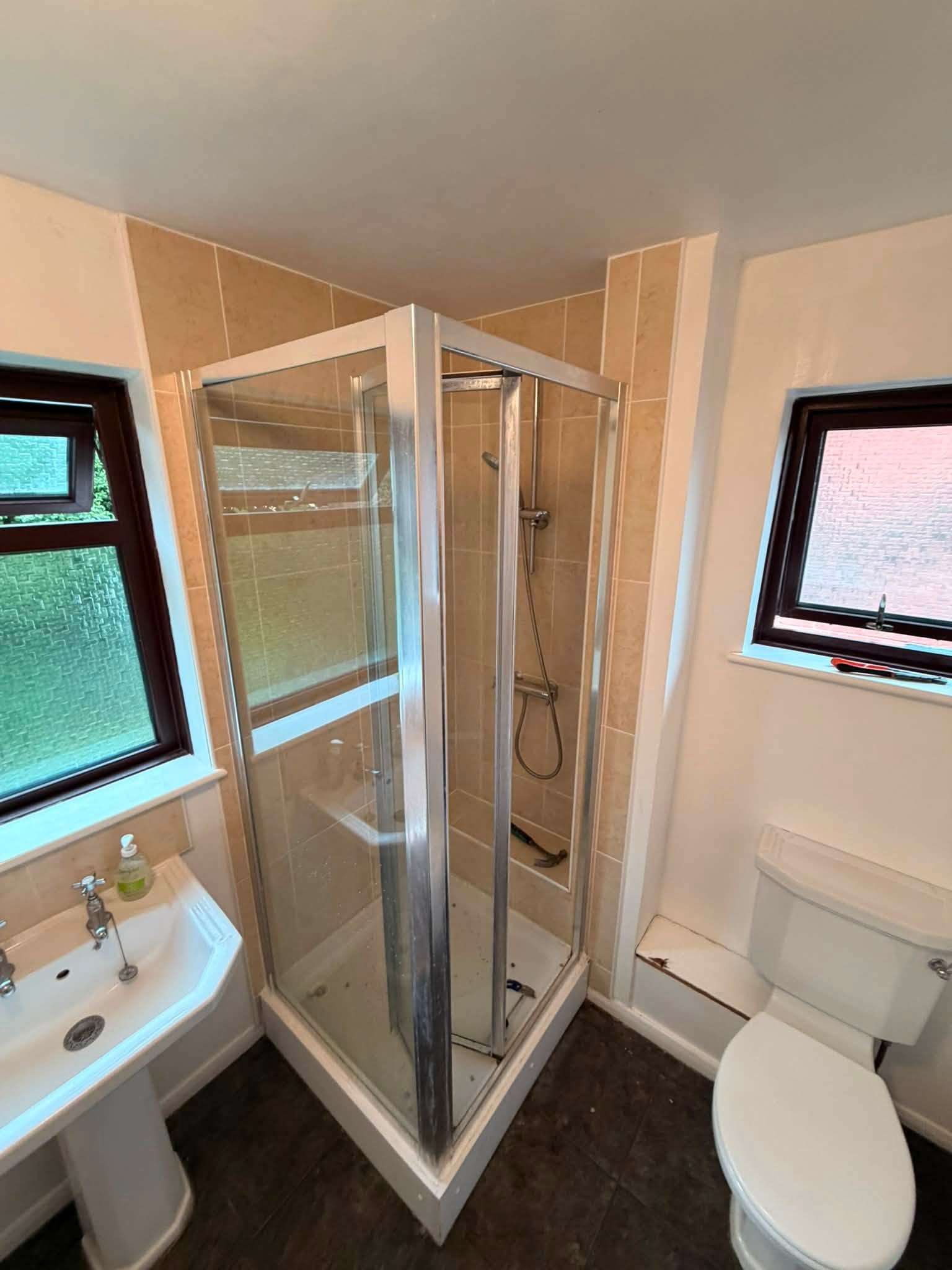 Before: the old corner shower cubicle and pedestal basin