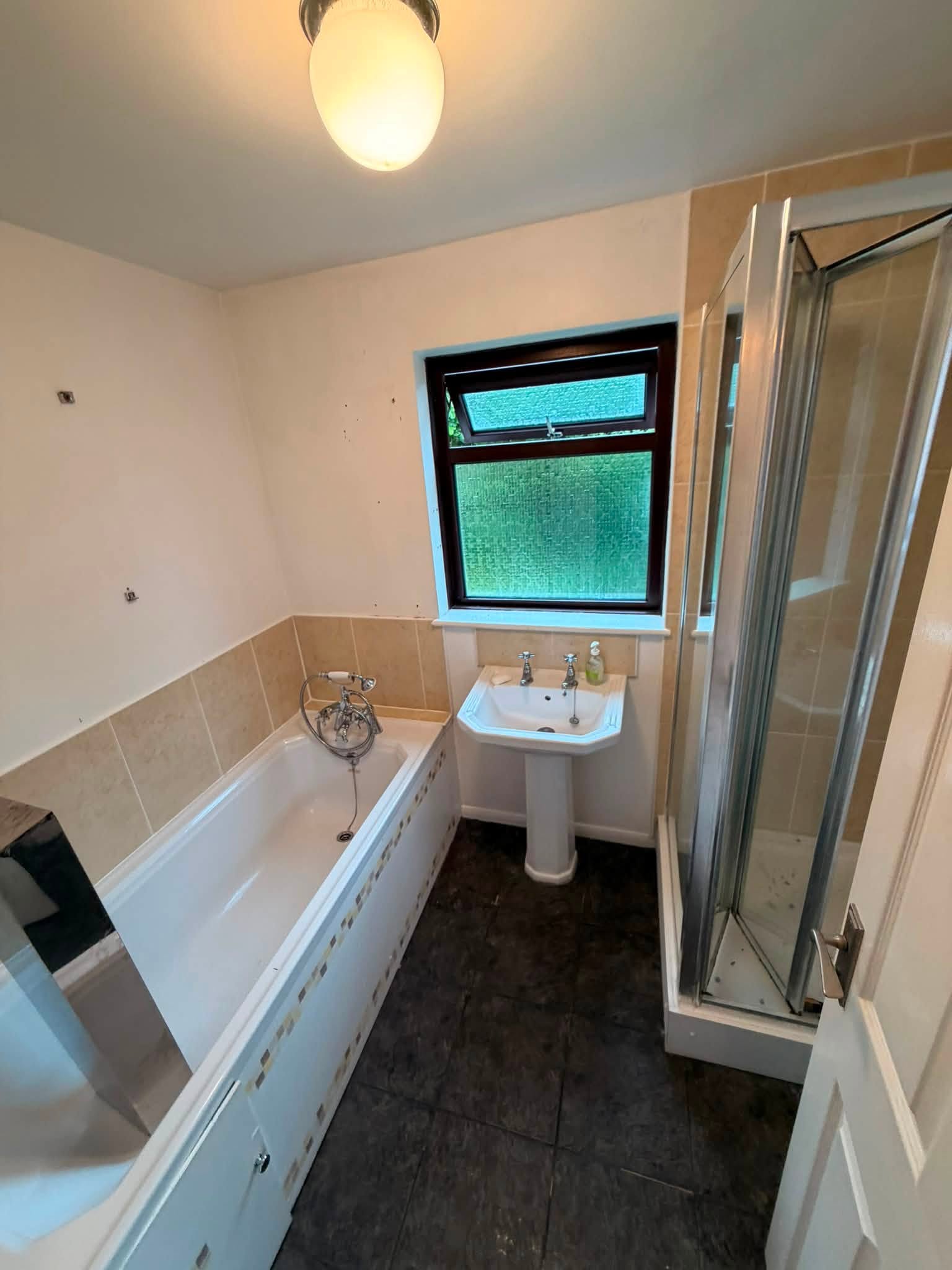 The bathroom before: an old bath, a corner shower cubicle and a pedestal basin